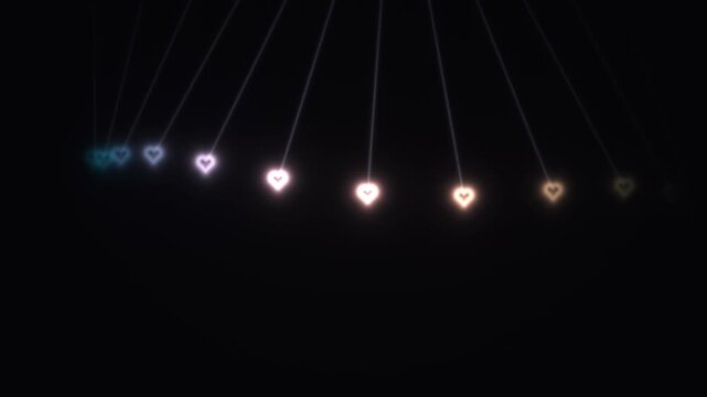 Hearts hanging from strings in dark background with soft glow