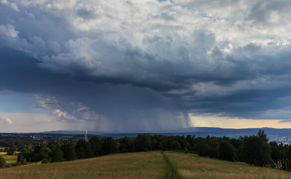 Impressive storm clouds with rain shafts over South Bohemian landscape and Klet mountain