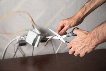 Fototapeta premium Caucasian man cutting internet cable with a scissors.