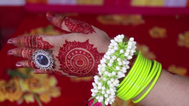 Intricate henna patterns on a bride hand with jasmine flower bracelet in motion video clip.