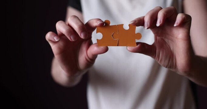 Hands assembling wooden puzzle pieces, focused problem solving, tactile game activity, wooden toy interaction, indoor leisure