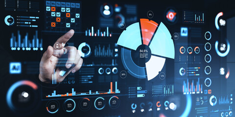 Fototapeta premium Business hand interacting with futuristic digital dashboard full of charts, analytics and data visual elements for corporate insights.