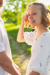 Naklejka premium Young couple enjoying a sunny day outdoors with a gentle smile