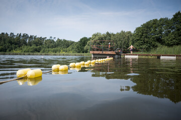 Obraz premium Buoys marking the area of ​​a supervised swimming zone. A lakeside swimming area in summer. 