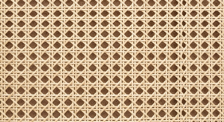 Fototapeta premium Detailed close-up of natural rattan cane webbing with geometric woven pattern and brown backing