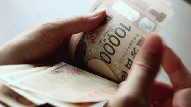 一万円札を数える女性の手元　お金　日本円　