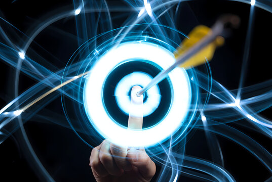 A hand holding a glowing target with an arrow in the center, surrounded by blue lines and lights on a dark background.