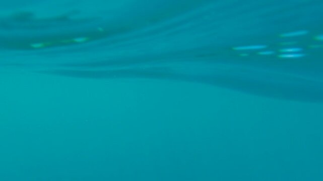 Kayak paddle rowing in blue water. Kayak paddle rowing through translucent turquoise waters near rocky coastline, generating gentle ripples while revealing underwater landscape