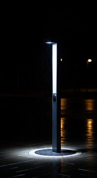 Modern LED Bollard Light Illuminating a Wet Walkway at Night