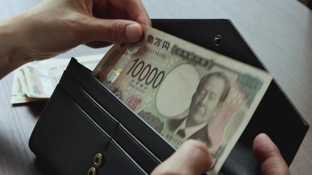 一万円札と長財布　お財布からお金を出す女性の手元　日本　1万円札