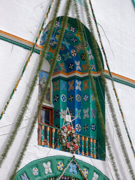 Decorated entrance of San Lorenzo Church in Zinacant&aacute;n, Chiapas, featuring vibrant floral motifs, traditional indigenous art, and colorful architectural details.