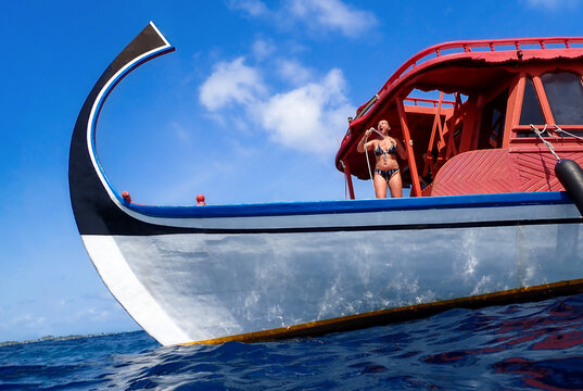 Woman Standing on Traditional Maldivian Dhoni Boat in Ocean