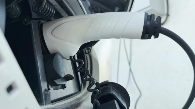 The electric vehicle charger connects to the port, powering the car. This efficient process feels modern and hopeful, representing a clean, sustainable future for transport.