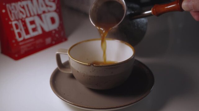Pouring coffee from cezve into cup