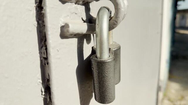 A metal padlock hangs securely on a light door. This simple scene feels calm and protective, suggesting a quiet secret kept safe behind the metal.
