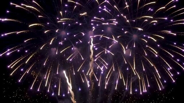 Colorful fireworks exploding in the night sky creating a vibrant celebration display in this high quality motion video footage clip