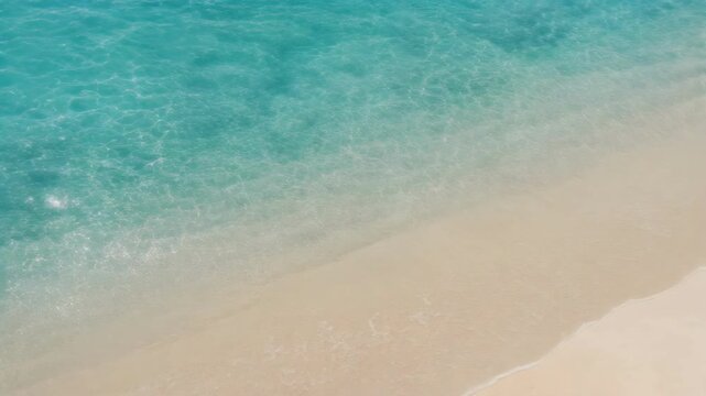 Clear turquoise ocean water gently washing onto a sandy beach shore