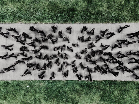 Aerial view of the Nierozpoznani sculpture installation by Magdalena Abakanowicz featuring numerous headless figures on a concrete path in Park Cytadela in Poznan, Wielkopolskie, Poland.