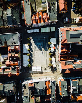 Aerial view of the historic town square with red-roofed buildings, white market stalls, and cobblestone patterns in Grudziadz, Kuyavian-Pomeranian, Poland.