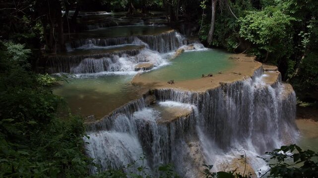 Turquoise Water Cascading Over Limestone Tiers In Lush Tropical Forest At Huai Mea Khamin Waterfall In Kanchanaburi Thailand