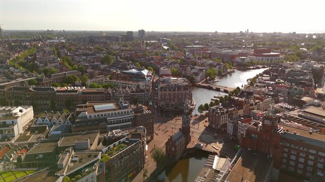 Drone flies forward while orbiting above Amsterdam at sunrise revealing the Amstel river and sprawling canal network