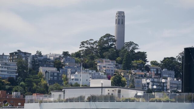 Coit Tower Atop Telegraph Hill On Residential Hillside  - Low, Wide Shot