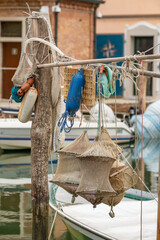 Fototapeta premium Traditional fishing nets and blue buoys hanging in a harbor, Chioggia, Italy