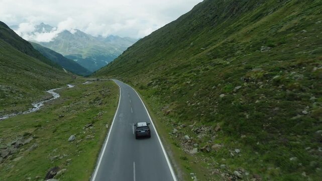 Aerial view of the High Alpine Road, Austria. A scenic mountain highway a car with tourists drives along the road between mountain ranges traveling through Europe.