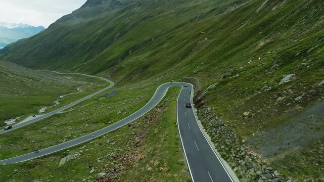 Aerial view of a car driving along the High Alpine Road in Austria. Descending the mountain pass via a winding road; picturesque Tyrolean landscapes tourism and travel in Europe.