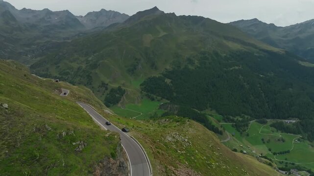 Aerial view of the Timmelsjoch High Alpine Road in Austria with a tourist car driving through spectacular mountain ranges and scenic landscapes in Europe