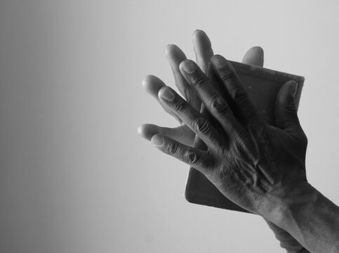 A serene portrait of a man praying with hands together in deep prayer that perfectly captures themes of faith, hope, mindfulness, and inner peace stock image stock photo