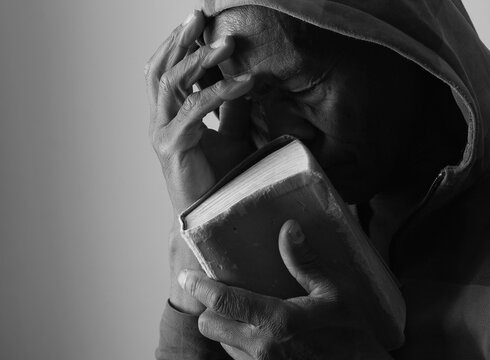 A serene portrait of a man praying with hands together in deep prayer that perfectly captures themes of faith, hope, mindfulness, and inner peace stock image stock photo