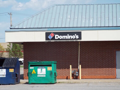 Gatineau,Quebec, Canada &ndash; May 21, 2026:A brick building facade displays the "Domino's" logo, with waste (d&eacute;chets) dumpsters placed outside the commercial establishment at 25 Chem. de la Savane.