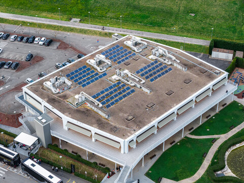 Aerial view of the modern shopping complex with solar panels on the roof and a parking area in Leccio, Toscana, Italy.