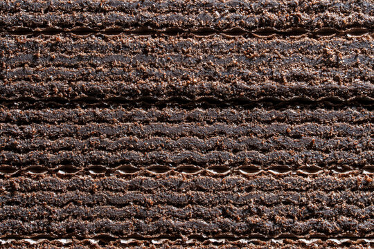 Macro texture of chocolate wafer layers. Full frame delicious chocolate covered wafer layers with cream filling showing detailed crunchy texture and crumbs for bakery confectionery background