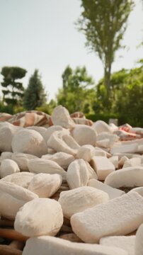 Close-up of traditional Uzbek qurut, also known as kurt, arranged outdoors in natural sunlight. Authentic Central Asian dried yogurt cheese snack with rich texture
