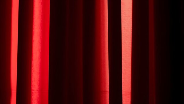 Deep red velvet curtain folds creating soft shadows in dramatic light.