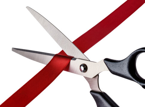 Isolated pair of black handled scissors cutting a vibrant red ribbon for a grand opening event