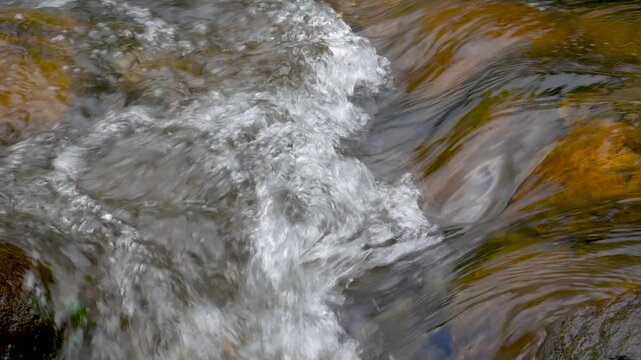 Looping clear stream water forming gentle bubbles over stones. Ideal for meditation visuals, ASMR ambience, nature backgrounds, and calming edits.