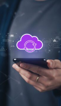 Hand holding a smartphone with a glowing purple cloud sync icon, representing data transfer and cloud computing services.