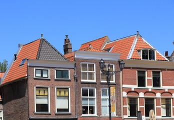 Obraz premium Brick Building Facades with Red Tiles Roofs and Vintage Lamppost in Delft, Netherlands