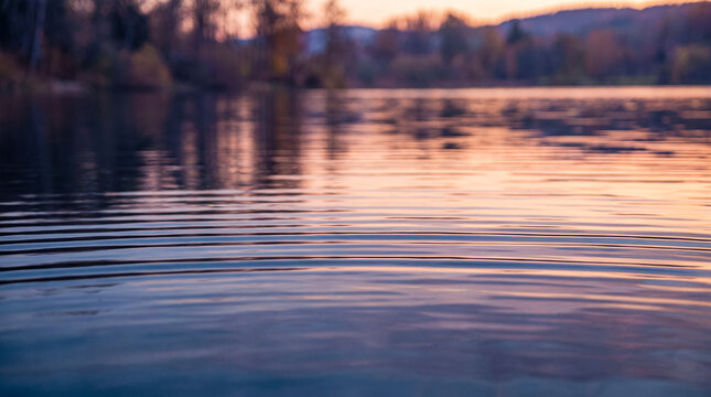 Calm lake surface with ripples at sunset Water