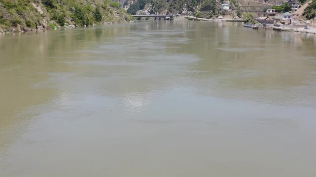 Flowing mountain Chenab river and steep rocky cliffs in the Indian Himalayas