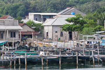 Karimunjawa jepara coastline with floating fish farm and traditional wooden stilt houses in Indonesia. © Faris Fitrianto