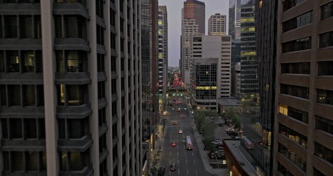 Calgary AB Canada Aerial v61 low drone flyover downtown commercial in between high rise buildings along 5 Ave Sw capturing cityscape and street traffic at dusk - Shot with Mavic 3 Pro Cine - July 2023