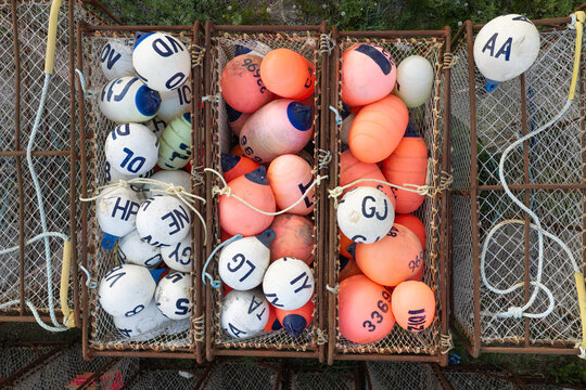 Aerial view of fishing traps filled with colorful white and orange buoys used for crab fishing in Unalaska, Alaska, United States.
