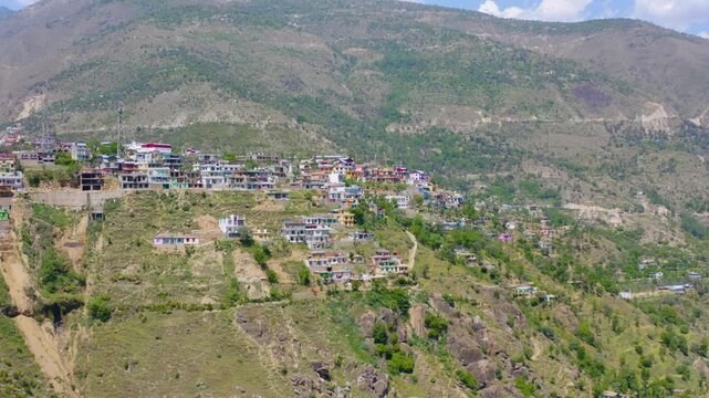 Wide establishing shot of Doda Town framed by evergreen trees in Jammu.