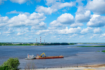 Fototapeta premium A barge with a crane is located on the river; the river is actively used for cargo transportation and commercial activities.