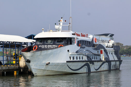 The Express Bahari 1C fast ferry boat docked at the harbor pier, preparing to transport passengers across the sea. Jepara, Indonesia.