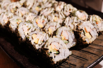 Stack of Japanese sushi maki roll in black plate. Served in Japanese bar restaurant © cocorattanakorn